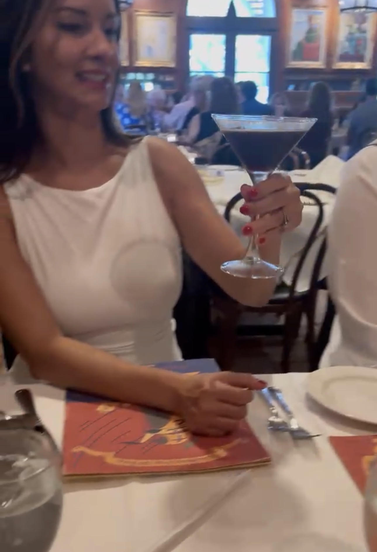 A Book Fetish Momma member holding up her espresso martini at dinner