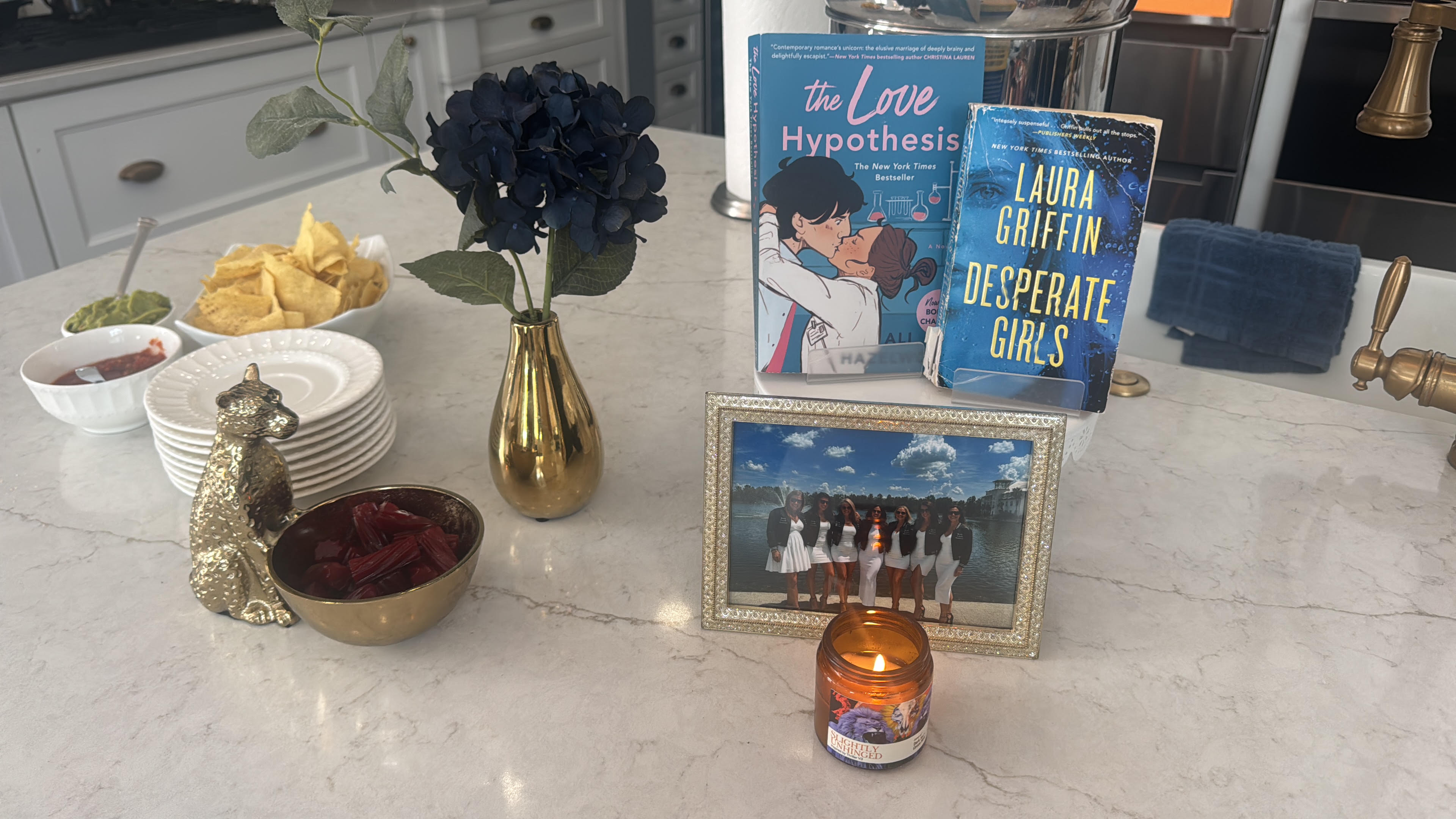 Book Fetish Momma book club members in white dresses and black bomber jackets, with July’s picks The Love Hypothesis and Desperate Girls
